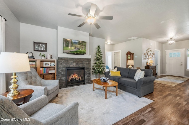 living room featuring a stone fireplace, hardwood / wood-style flooring, and ceiling fan