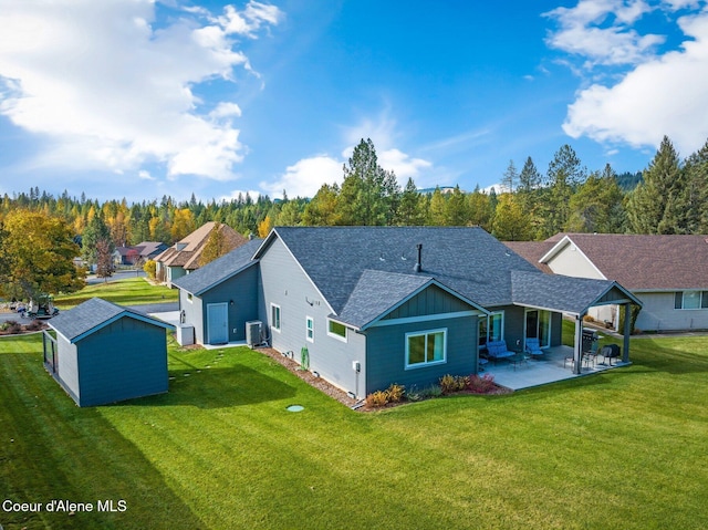 rear view of house with central AC unit, a storage shed, a patio area, and a lawn