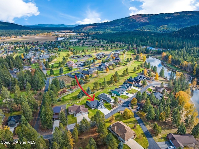 drone / aerial view featuring a water and mountain view