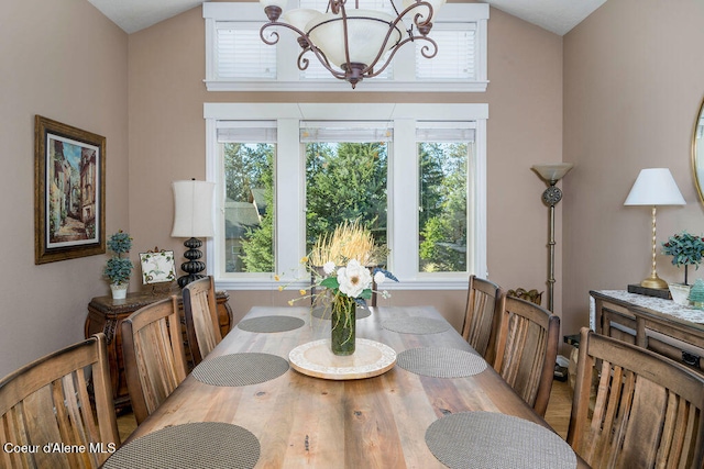 dining space with a chandelier, a healthy amount of sunlight, and lofted ceiling