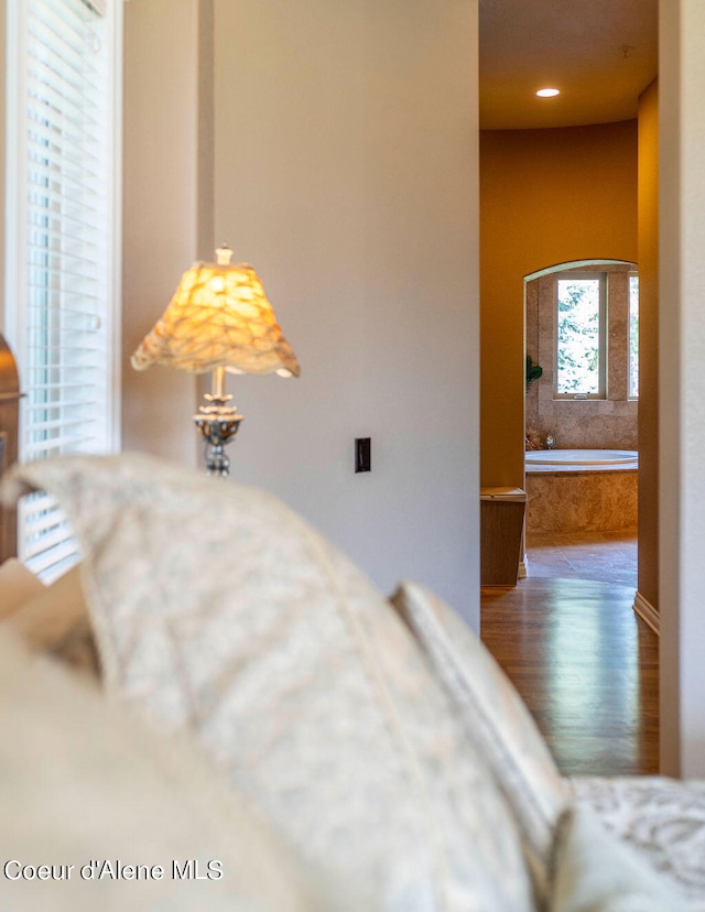 bedroom with wood-type flooring and connected bathroom