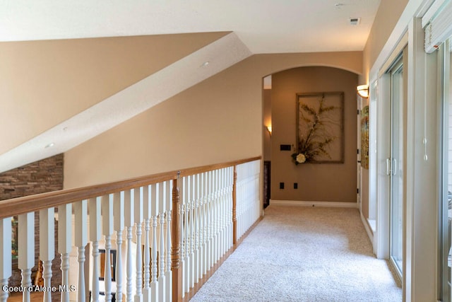 corridor featuring light carpet and vaulted ceiling