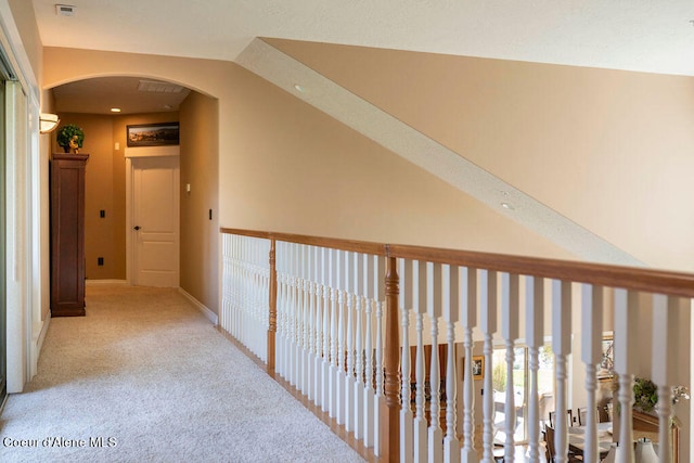 hall featuring light carpet and vaulted ceiling