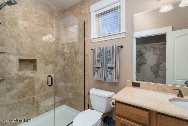 bathroom with an enclosed shower, vanity, and toilet