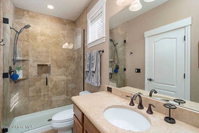 bathroom with vanity, toilet, and a shower with door