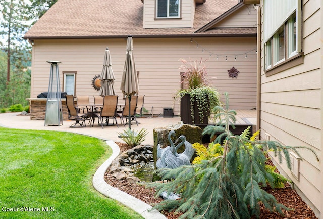 rear view of house featuring a yard and a patio area