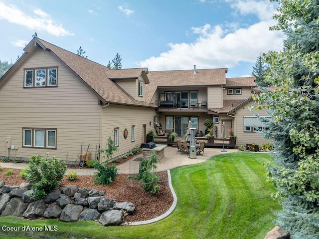 back of property featuring a patio, a balcony, and a yard