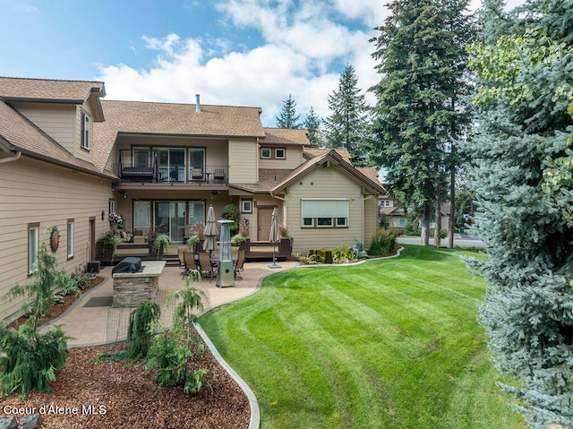 back of house featuring a lawn, a patio, and a balcony