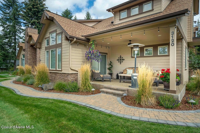 back of house with ceiling fan, a lawn, and a patio area