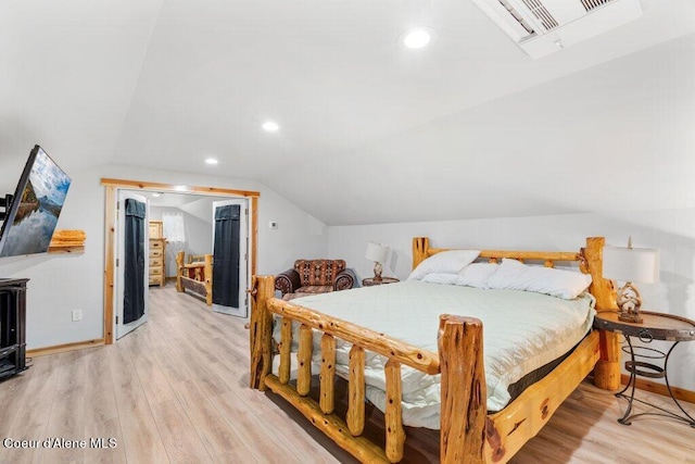 bedroom featuring light hardwood / wood-style floors and vaulted ceiling