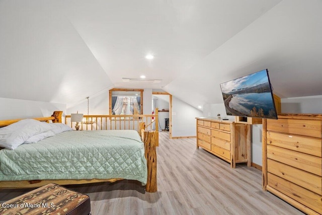 bedroom with vaulted ceiling and light wood-type flooring