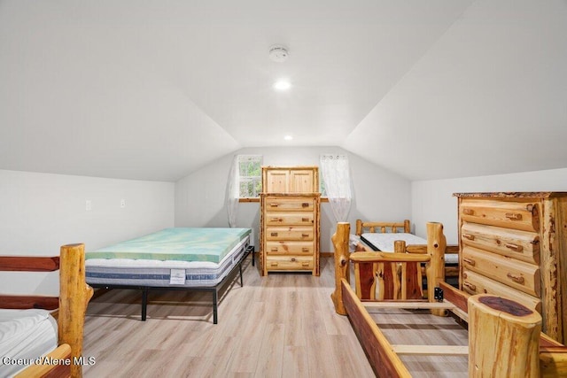 bedroom with vaulted ceiling and light hardwood / wood-style floors