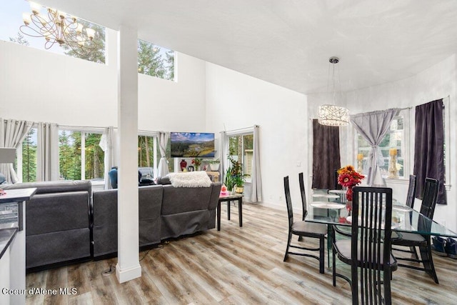 dining space featuring light hardwood / wood-style floors and a high ceiling