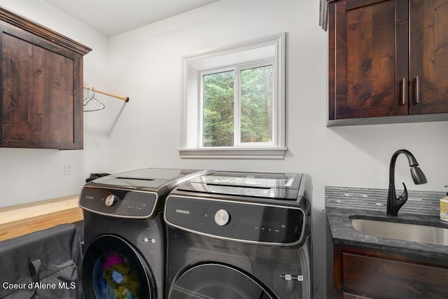 laundry area featuring cabinets, sink, and washing machine and clothes dryer