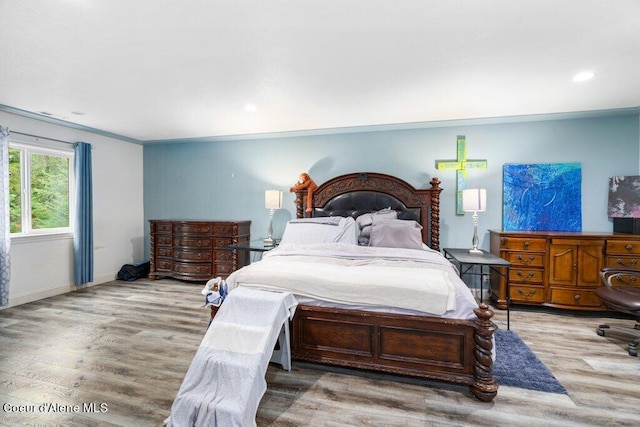 bedroom with wood-type flooring and ornamental molding