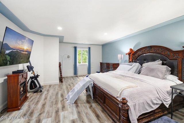 bedroom featuring ornamental molding and light wood-type flooring