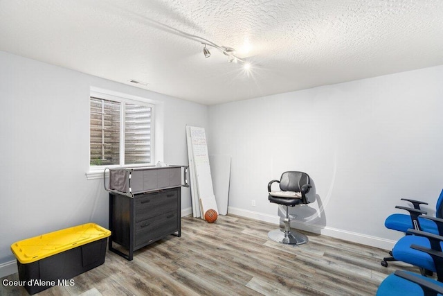 misc room featuring hardwood / wood-style flooring and a textured ceiling