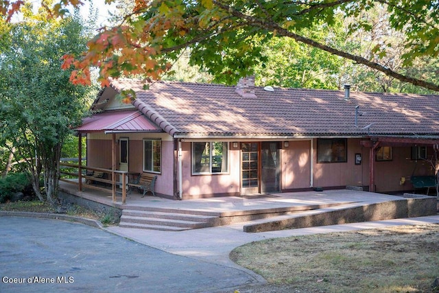 905 S Tanglewood Rd, Post Falls, ID 83854 - view of front of property with covered porch, a tiled roof, and a chimney