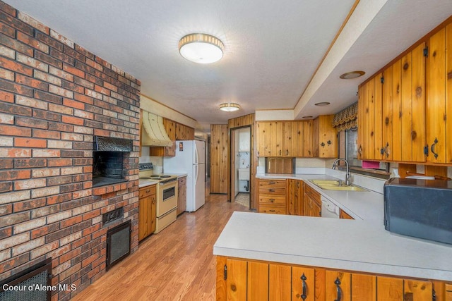 905 S Tanglewood Rd, Post Falls, ID 83854 - kitchen with white appliances, a brick fireplace, light countertops, ventilation hood, and a sink