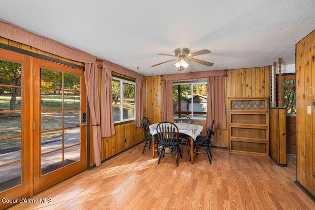 905 S Tanglewood Rd, Post Falls, ID 83854 - dining room featuring light wood-style floors, a ceiling fan, and wooden walls