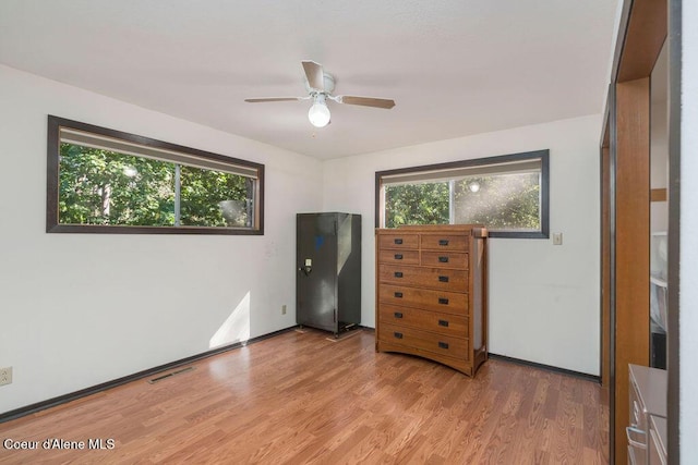 905 S Tanglewood Rd, Post Falls, ID 83854 - bedroom featuring multiple windows, light wood-style floors, a ceiling fan, and baseboards