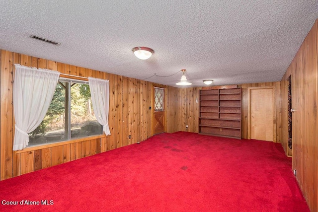 905 S Tanglewood Rd, Post Falls, ID 83854 - carpeted spare room featuring wood walls and a textured ceiling