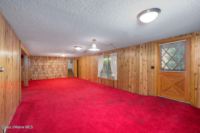 905 S Tanglewood Rd, Post Falls, ID 83854 - empty room with a textured ceiling, carpet, wooden walls, and plenty of natural light