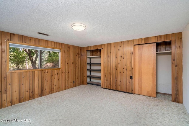 905 S Tanglewood Rd, Post Falls, ID 83854 - unfurnished bedroom featuring carpet flooring, wooden walls, and a textured ceiling