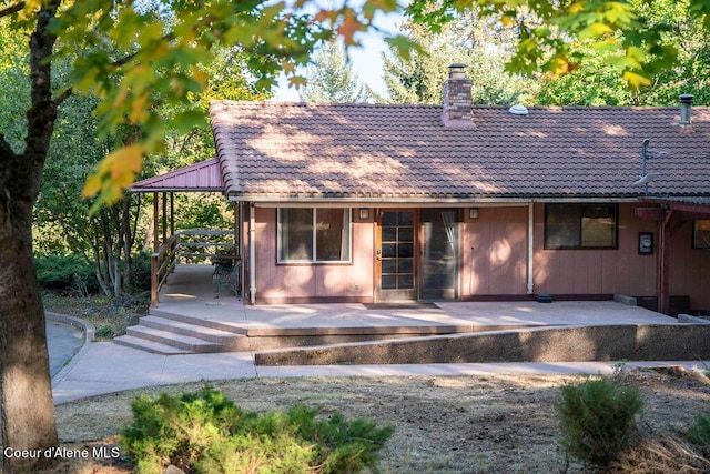 905 S Tanglewood Rd, Post Falls, ID 83854 - rear view of house featuring a tile roof, a chimney, and a patio