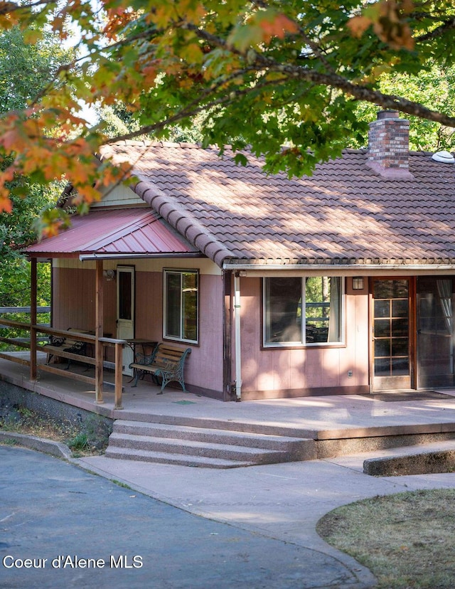 905 S Tanglewood Rd, Post Falls, ID 83854 - view of front of home featuring covered porch, a chimney, and a tile roof