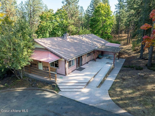 905 S Tanglewood Rd, Post Falls, ID 83854 - view of front facade featuring driveway, a chimney, an attached garage, and covered porch