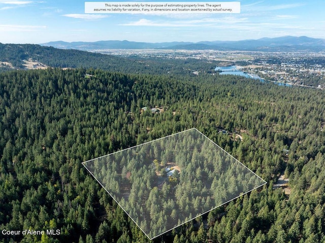 905 S Tanglewood Rd, Post Falls, ID 83854 - view of property location with a heavily wooded area, a mountainous background, and property boundaries highlighted
