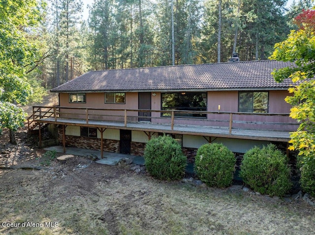 905 S Tanglewood Rd, Post Falls, ID 83854 - back of property with a chimney, a wooden deck, a tile roof, and stone siding