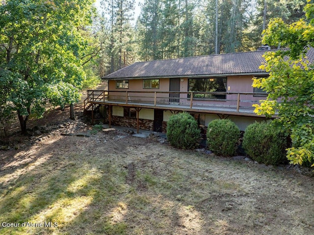 905 S Tanglewood Rd, Post Falls, ID 83854 - back of house featuring a deck, stairway, stone siding, and a forest view