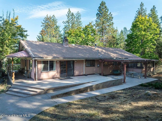 905 S Tanglewood Rd, Post Falls, ID 83854 - view of front of property featuring a patio area, a chimney, and a tiled roof