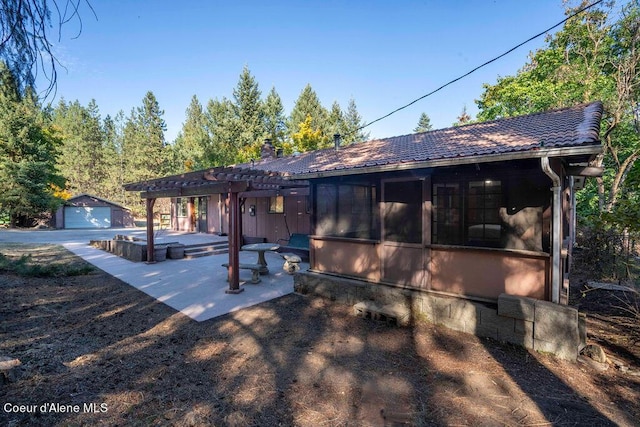 905 S Tanglewood Rd, Post Falls, ID 83854 - view of front of property featuring a pergola, an outdoor structure, a patio, a tiled roof, and a chimney