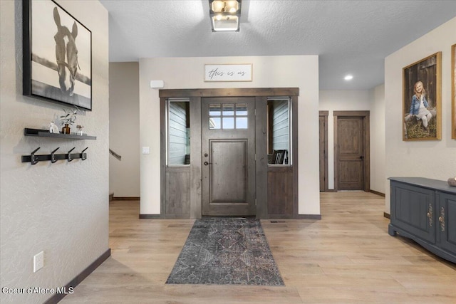 entrance foyer featuring a textured ceiling and light wood-type flooring