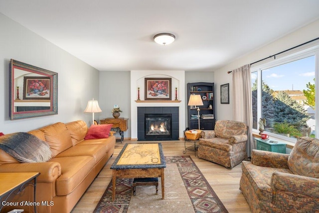 living room with light hardwood / wood-style floors and a tiled fireplace