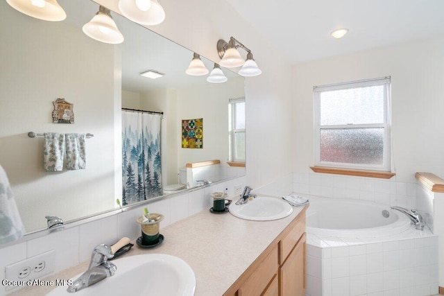 bathroom with vanity, toilet, and a relaxing tiled tub