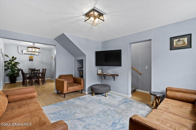 living room with light hardwood / wood-style flooring and a notable chandelier