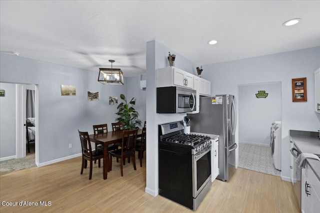 kitchen featuring stainless steel appliances, a chandelier, light wood-type flooring, and white cabinets