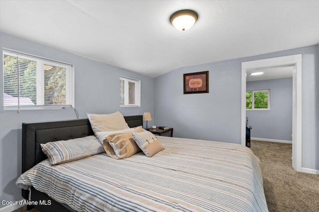 bedroom with lofted ceiling, carpet, and multiple windows