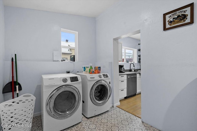 laundry room featuring sink, light hardwood / wood-style flooring, washer and dryer, and plenty of natural light