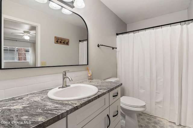 bathroom featuring backsplash, toilet, ceiling fan, a shower with curtain, and vanity