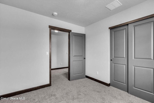 2711 E Cinder Ave, Post Falls, ID 83854 - unfurnished bedroom featuring carpet flooring, baseboards, a textured ceiling, and a closet