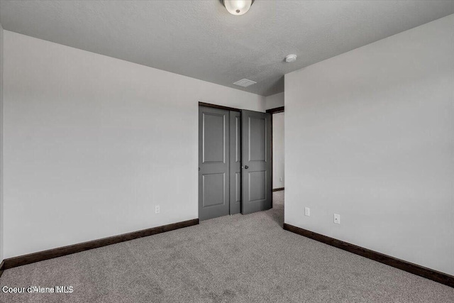 2711 E Cinder Ave, Post Falls, ID 83854 - unfurnished bedroom featuring baseboards, carpet, a textured ceiling, and a closet
