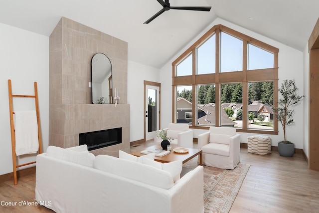 11996 N Rocking R, Hayden, ID 83835 - living room featuring a ceiling fan, a fireplace, high vaulted ceiling, and light wood-type flooring
