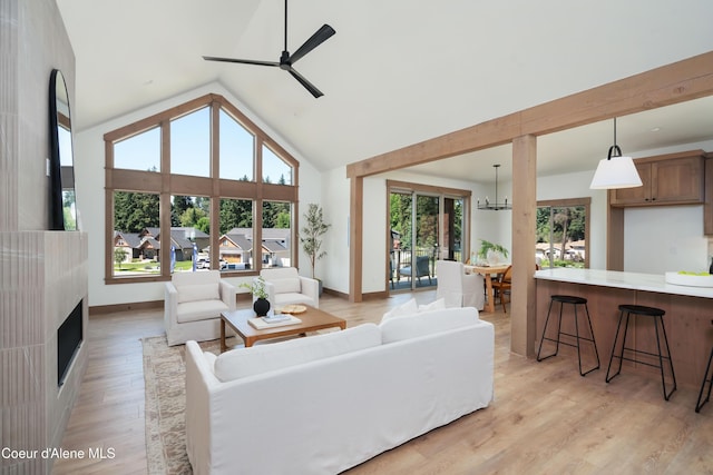 11996 N Rocking R, Hayden, ID 83835 - living room with light wood-style floors, a ceiling fan, high vaulted ceiling, and a fireplace