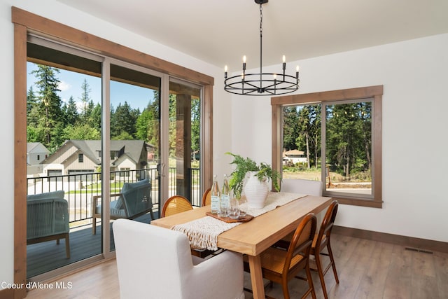 11996 N Rocking R, Hayden, ID 83835 - dining area with a chandelier, plenty of natural light, and light wood-style flooring