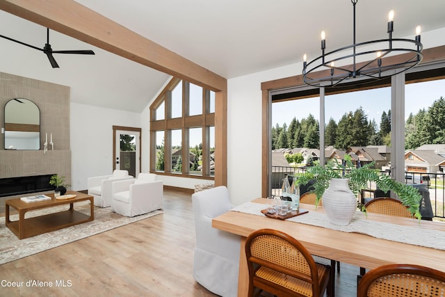 11996 N Rocking R, Hayden, ID 83835 - dining space with a chandelier, wood finished floors, lofted ceiling, a fireplace, and a ceiling fan
